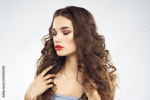 woman with bare shoulders wavy hairstyle glamor makeup light background