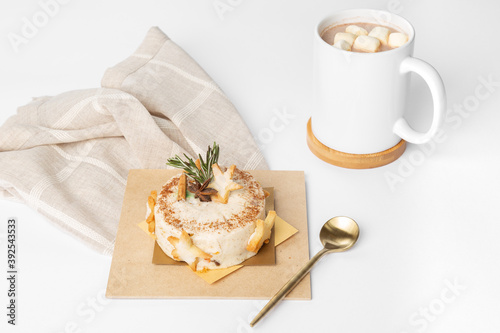Dessert pastry on wooden plate with golden spoon and chocolate with marshmallows