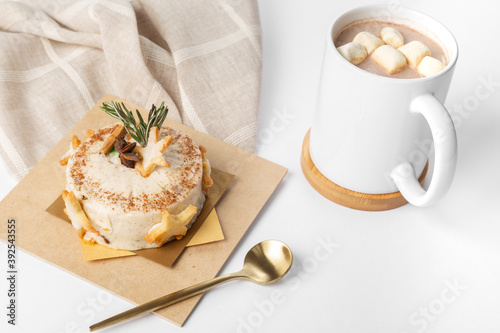 Dessert pastry on wooden plate with golden spoon and chocolate with marshmallows