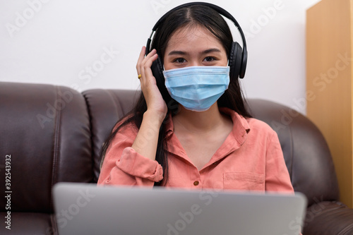 woman in face mask with laptop during Learning at home