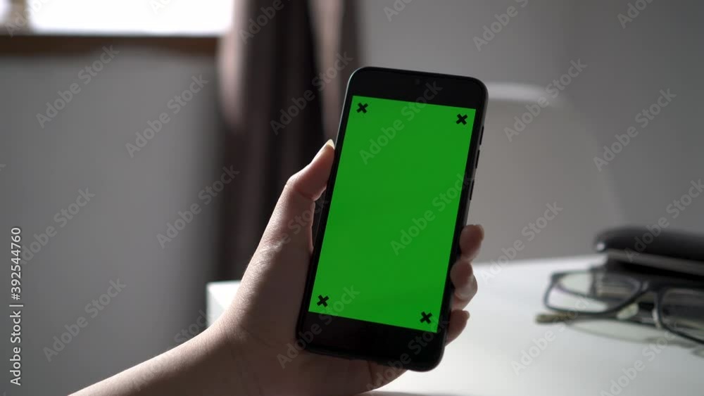 Close up view of hand operating smartphone with green screen Close up view of hand operating smartphone with green screen