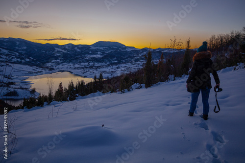 Photographers photographing winter lake mountain scene in sunset, alone in wilderness