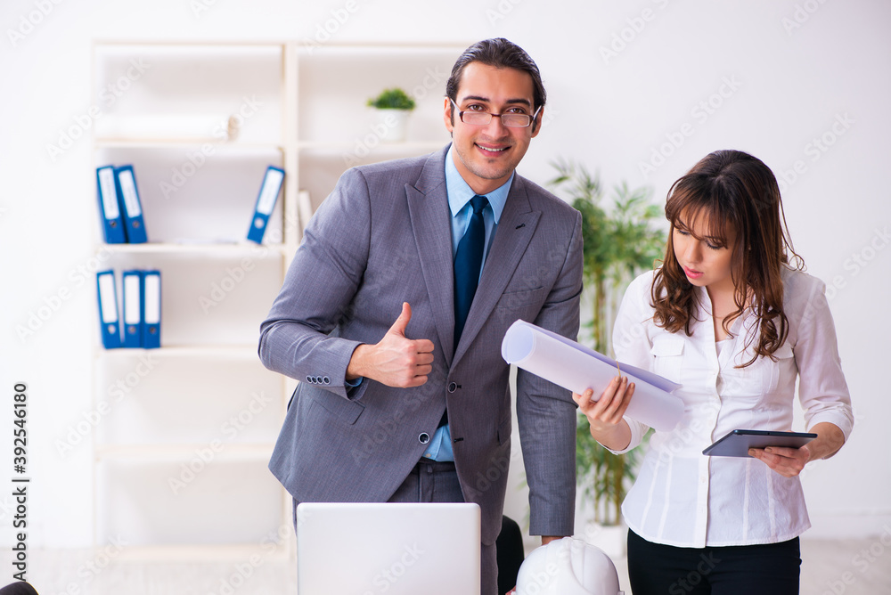 Young businessman and female architect discussing new project Young businessman and female architect discussing new project