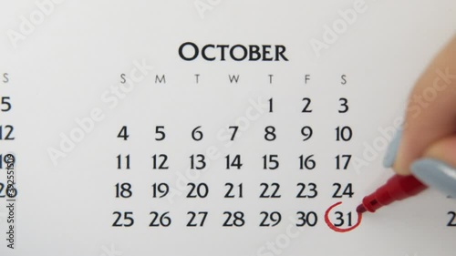 Female hand circle day in calendar date with a red marker. Business Basics Wall Calendar Planner and Organizer. November 31th