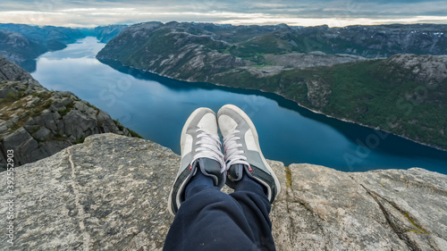 Man resting at the top of Pulpit Rock with a fjord at Preikestolen under beautiful norway landscape and nature, Pulpit Rock, Norway © CanYalicn