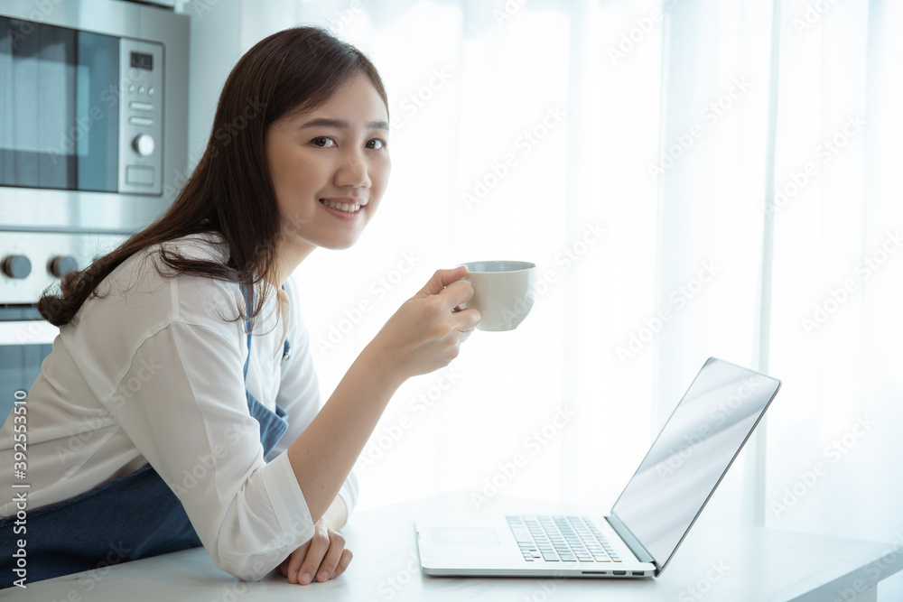 Cheerful Asian woman enjoy drinking a cup of coffee and browsing the internet for social media in the morning. Cheerful Asian woman enjoy drinking a cup of coffee and browsing the internet for social media in the morning.