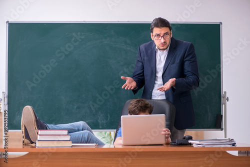 Young male teacher and schoolboy in the classroom