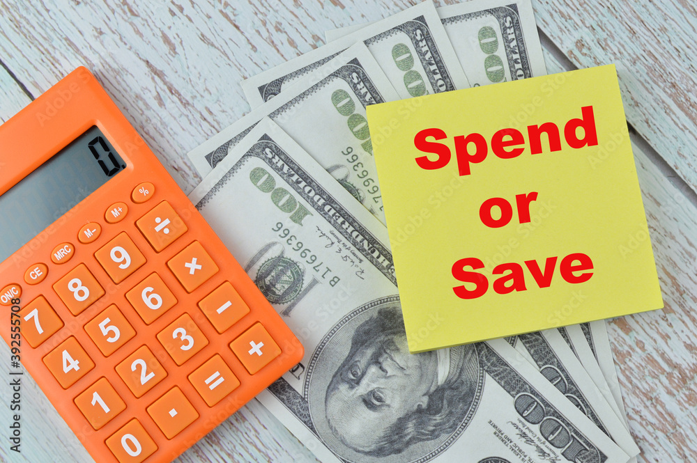 Selective focus of banknotes, calculator and memo note written with text SPEND OR SAVE. Financial concept. Selective focus of banknotes, calculator and memo note written with text SPEND OR SAVE. Financial concept.