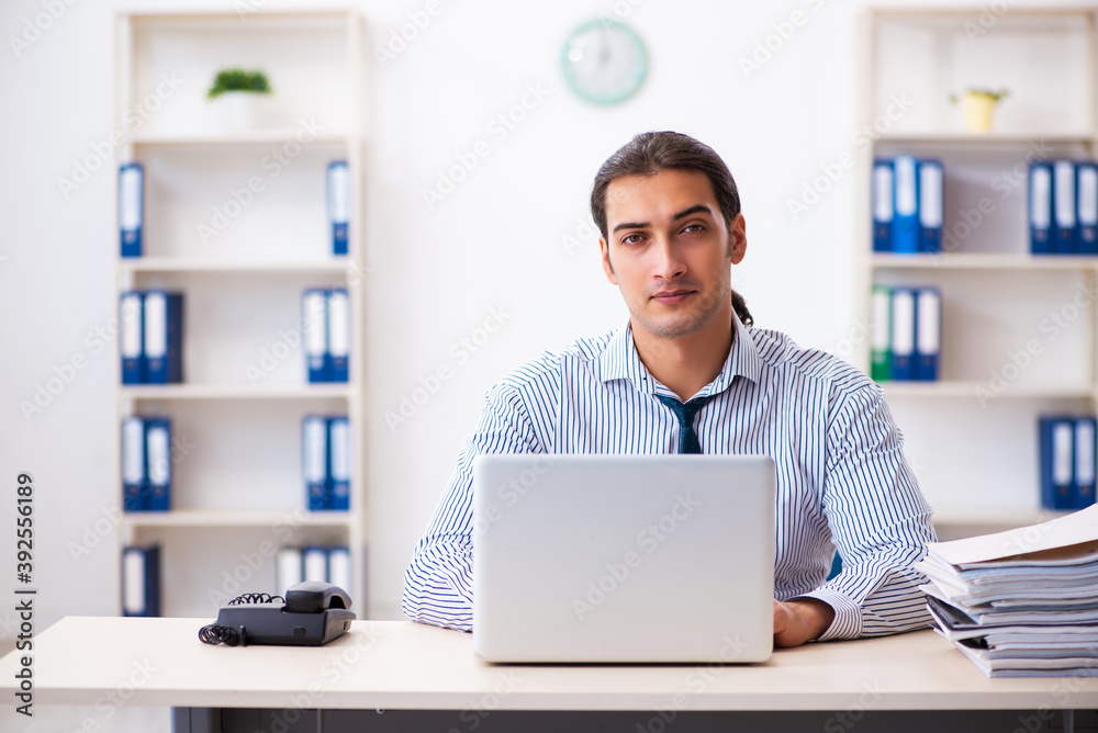 Young male employee working in the office Young male employee working in the office