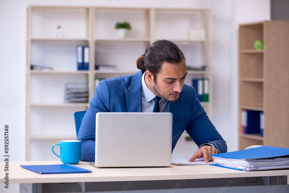 Young male employee working at workplace Young male employee working at workplace