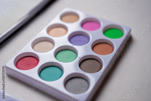 Watercolor palette on a white table in close up concept.
