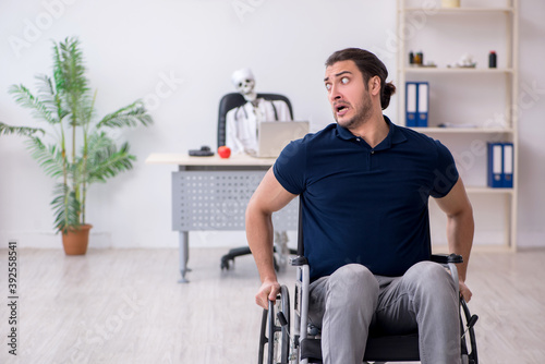 Young man in wheel-chair visiting dead doctor