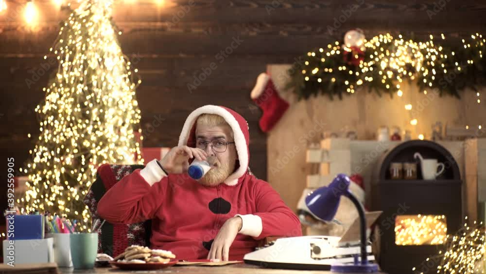 Crazy Repper Santa Claus sing rap or Hip Hop and drink milk at home near Christmas tree. Funny New Year Holiday. Crazy Repper Santa Claus sing rap or Hip Hop and drink milk at home near Christmas tree. Funny New Year Holiday.