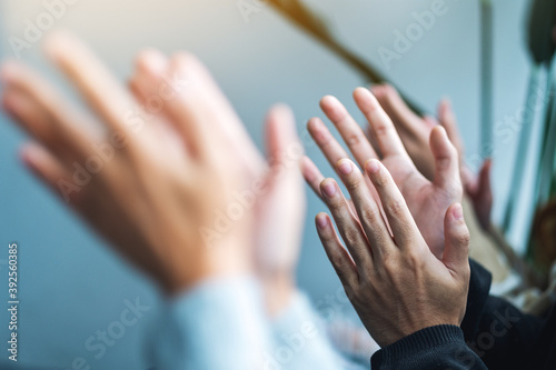 Closeup image of people clapping hands together