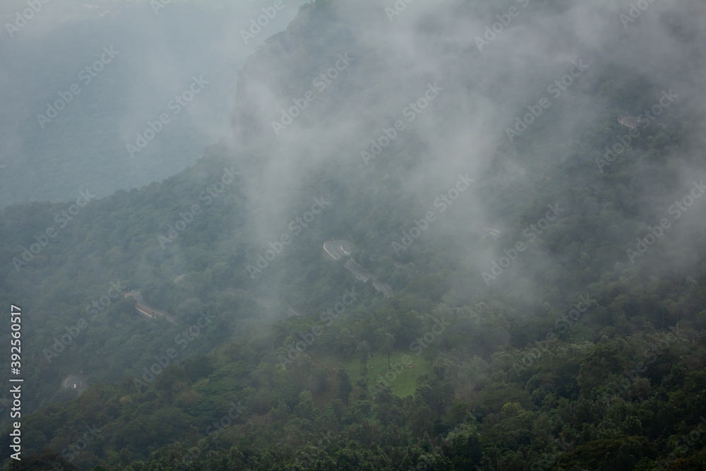 Scenic view of the foggy landscape with winding ghat road on the way to Yercaud, Salem, India.
