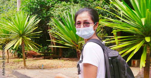 Tourist woman wear mask to portect diecease form the air , view from back . photo