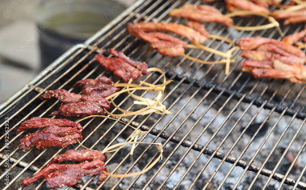 Closeup of grilled  meat on gridiron, Asian street food.