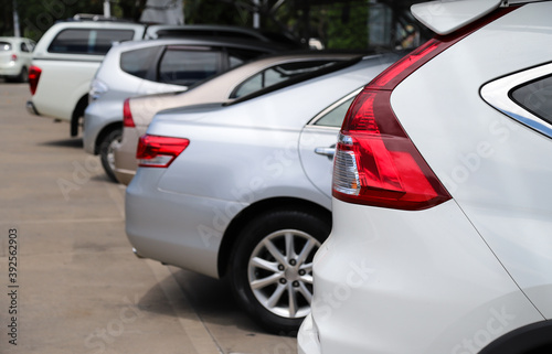 Closeup of rear side of white car and other cars parking in parking area. © Amphon