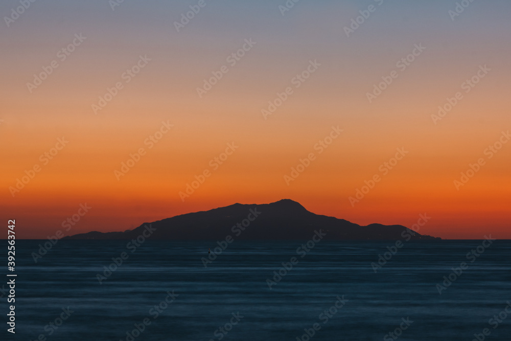 Sunset behind Ischia Island with Slhouette, an Orange and Teal or Blue Abstract Background