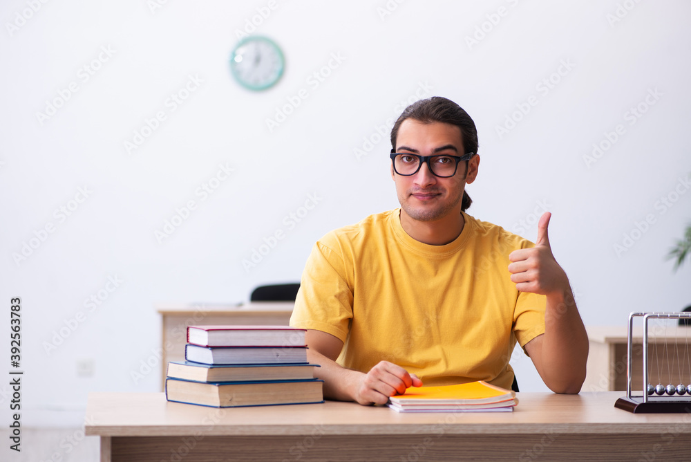 Young male student physics preparing for exams in the classroom Young male student physics preparing for exams in the classroom