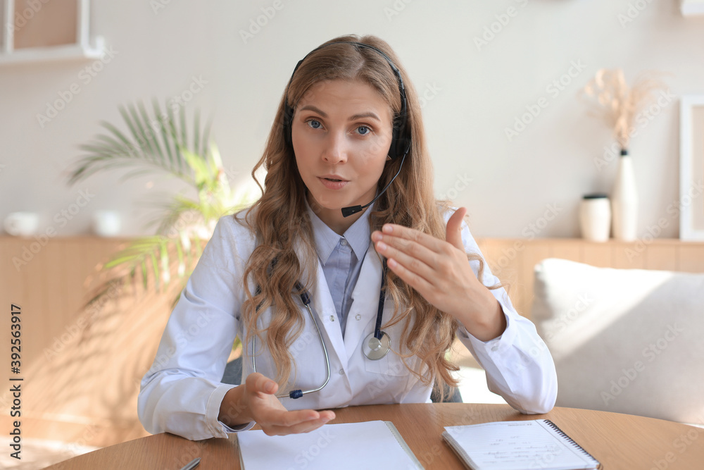 Smiling attractive female doctor talking at camera with patient. Smiling attractive female doctor talking at camera with patient.