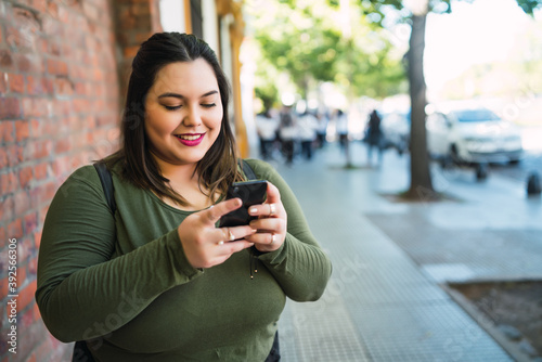 Wallpaper Mural Young plus size woman using her mobile phone. Torontodigital.ca