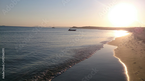 sunset at the beach and boats on the sea