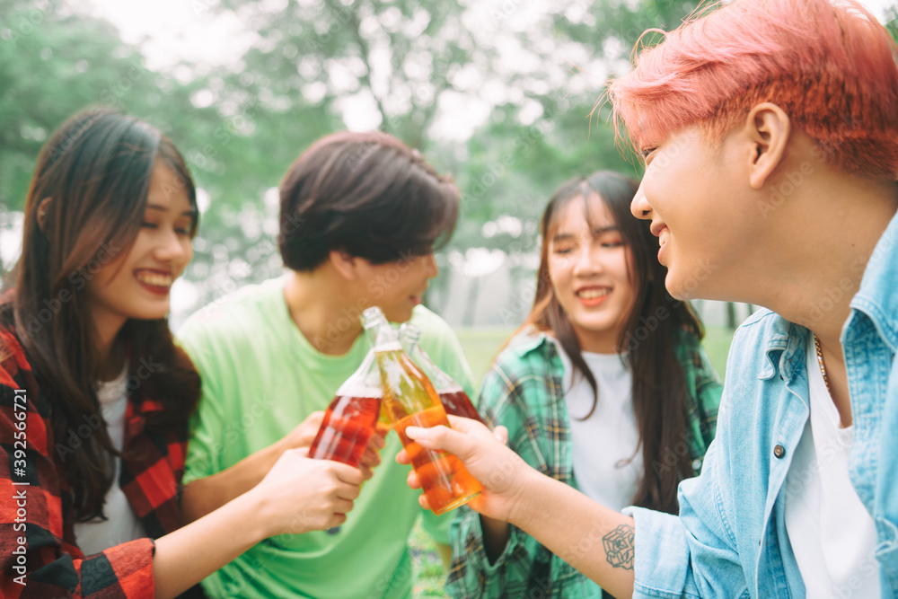 Group of young Asians happily drinking beer at a picnic at the park Group of young Asians happily drinking beer at a picnic at the park