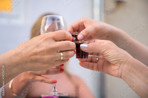 Wedding or party concept. girls Hands with a glass of dark liquor guest makes a toast  raising a glass