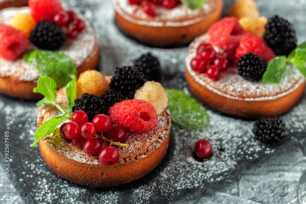 Fresh small homemade fruit tarts with raspberries, currants and blackberries Fresh small homemade fruit tarts with raspberries, currants and blackberries
