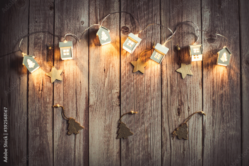 New year christmas background, glowing garland houses on wooden background