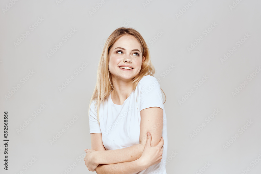 Cute blonde white t-shirt gesture with hands lifestyle light background Cute blonde white t-shirt gesture with hands lifestyle light background