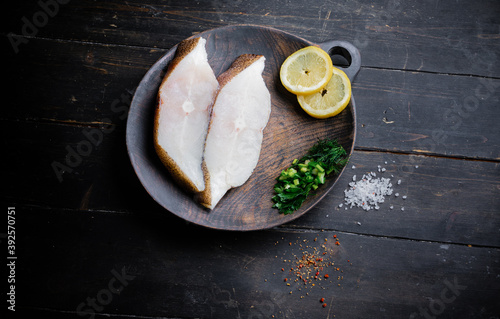 Obraz na plátně Frozen Greenland halibut steaks on the wood cutting board
