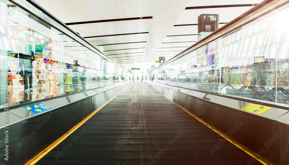 Empty travelator with morning light reflection in the air port terminal. passenger moving walkway. Travel and transportation concepts.