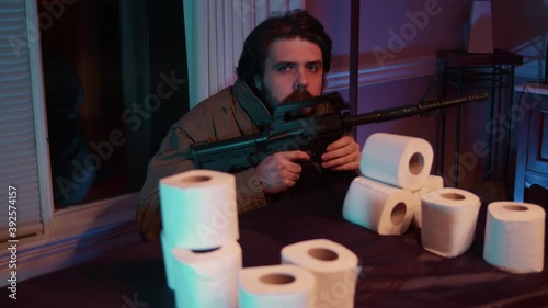 crazy guy gaurding toilet paper with gun photo