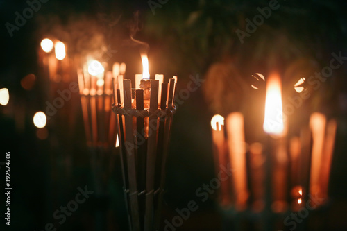 Row of bamboo Torches flaming at night