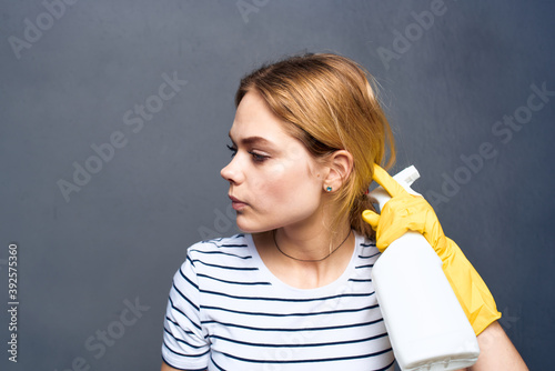 Cleaning lady with detergent home care service delivery gray background