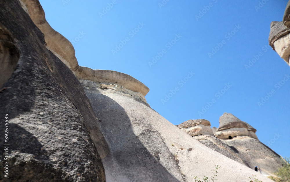 Stone tower on the top of mountain, blue sky, rock formation and stone caves 