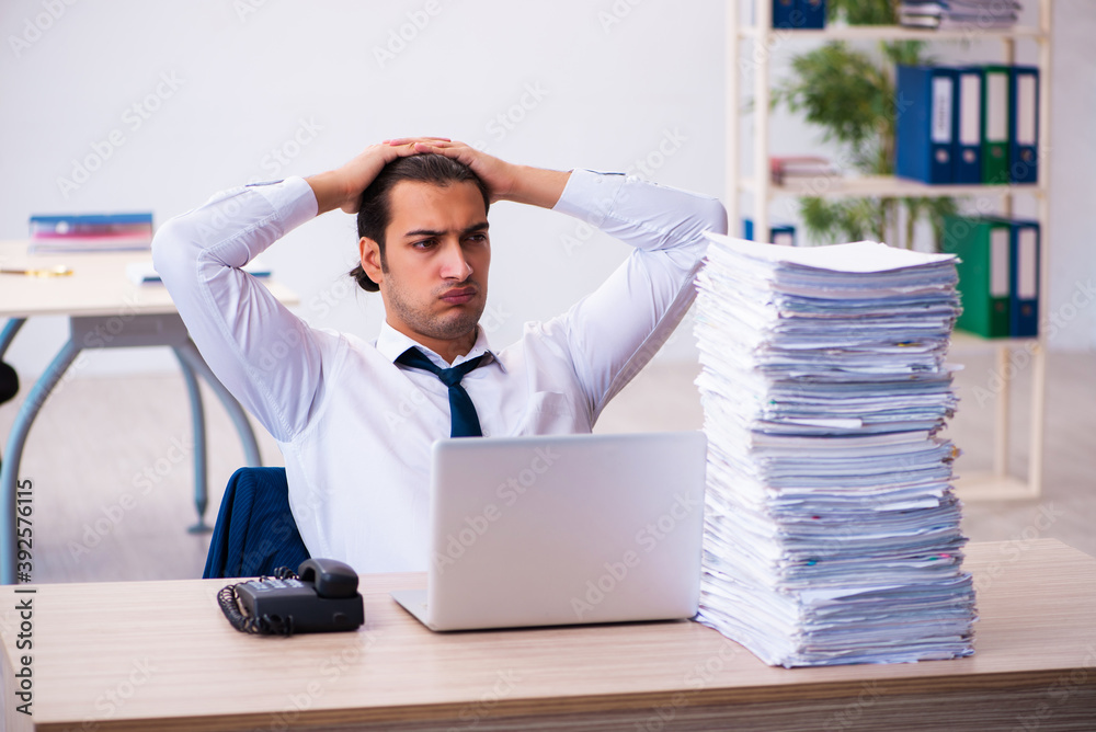 Young male employee unhappy with excessive work Young male employee unhappy with excessive work