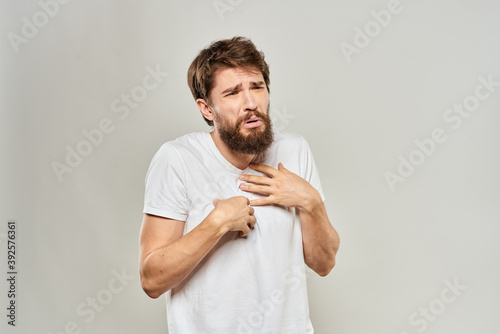 man in white t-shirt gesturing with his hands studio dissatisfaction lifestyle light background