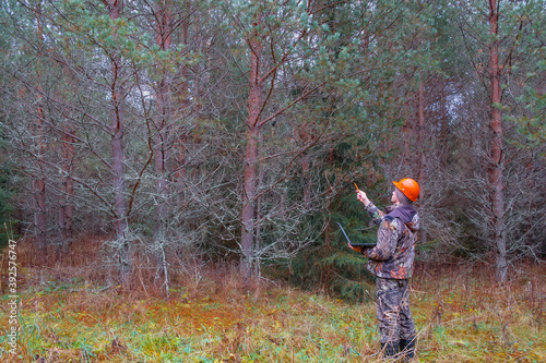 A forest engineer works in the forest with a computer. Forest worker performs forest inventory. Digital technologies in forestry.