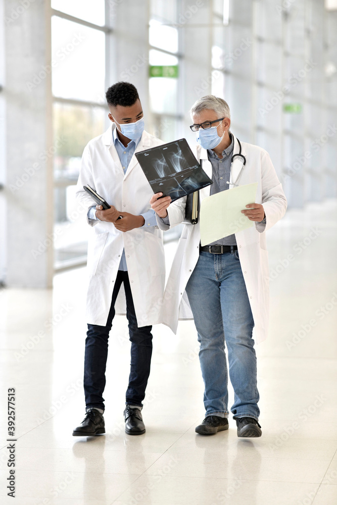 Doctor with medical intern analysing XR results Doctor with medical intern analysing XR results