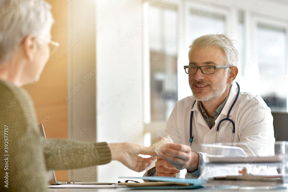 Obraz premium Mature practitioner in office listening to patient