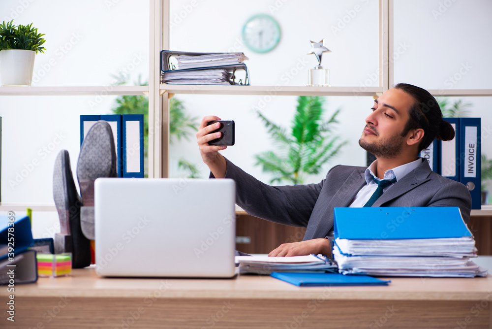 Young male employee and too much work in the office