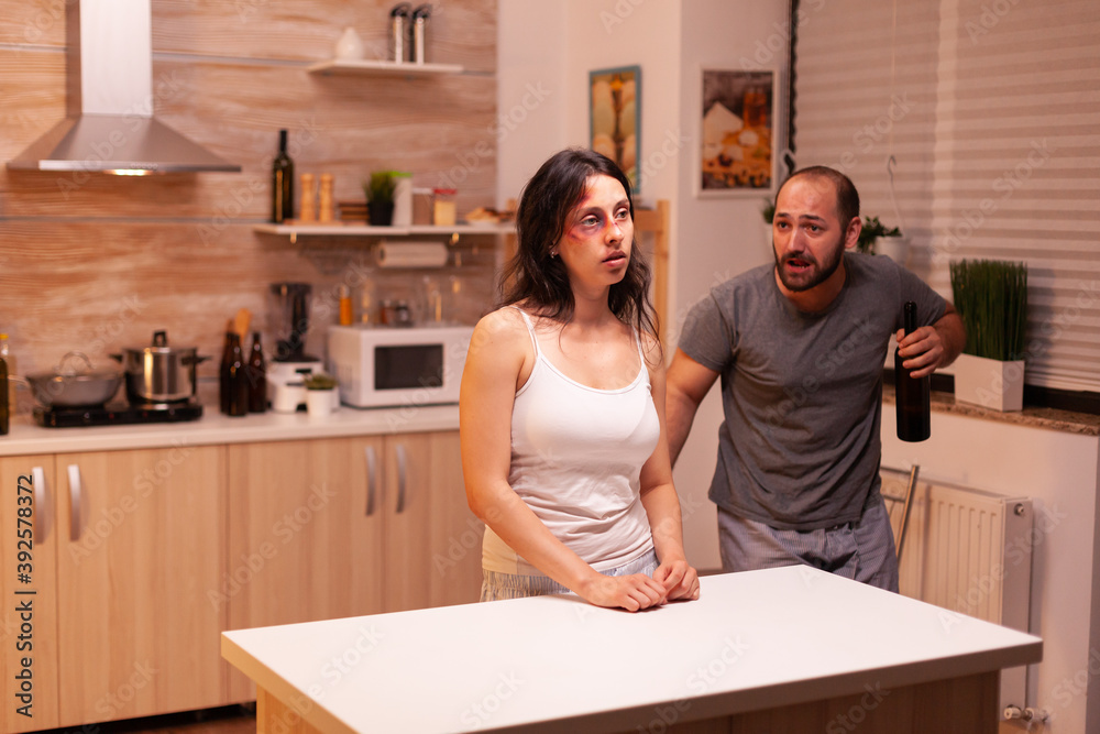 Husband being drunk looking at wife after being brutally violent with her. Violent aggressive man abusing injuring terrified helpless, vulnerable, afraid, beaten and panicked woman. Husband being drunk looking at wife after being brutally violent with her. Violent aggressive man abusing injuring terrified helpless, vulnerable, afraid, beaten and panicked woman.