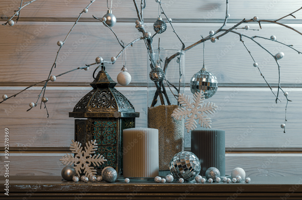 Vase with branches, candles, metal candlestick, balls in white and gray tones  in the center. Christmas decor.