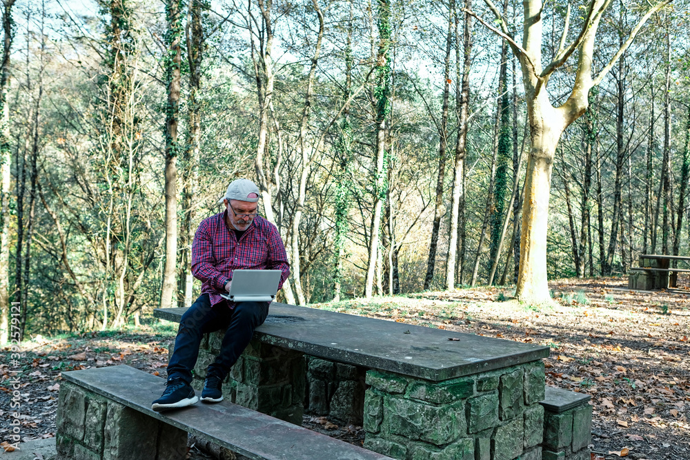 Fototapeta premium Mature man working with a laptop in the field