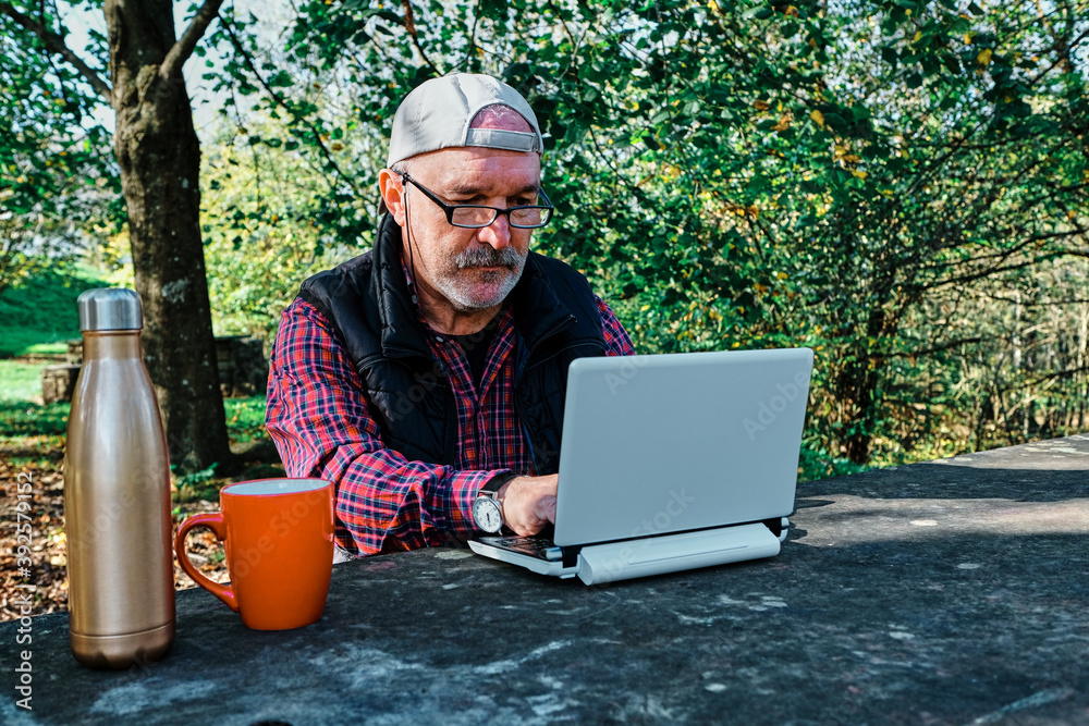 Mature man working with a laptop in the field