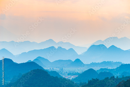Ha Giang karst geopark landscape in North Vietnam. Mountain silhouette stunning scenery mist and fog in the valleys at sunset. Ha Giang motorbike loop, famous travel destination bikers easy riders.