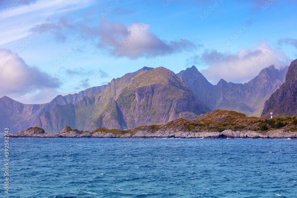 Open sea. View of the rocky seashore. Lighthouse on the shore. Beautiful nature of Northern Norway. Lofoten islands Open sea. View of the rocky seashore. Lighthouse on the shore. Beautiful nature of Northern Norway. Lofoten islands